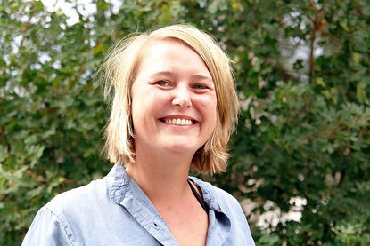 Sarah Stützinger - Copyright: Ev.-Luth. Kirchengemeinde Schwarzenbek Portraitbild von Pastorin Sarah Stützinger, sie steht vor einer grünen Hecke. - Copyright: Ev.-Luth. Kirchengemeinde Schwarzenbek