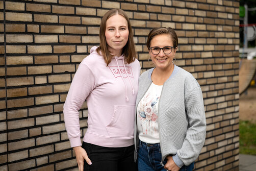 2 Frauen vor einer Backsteinwand